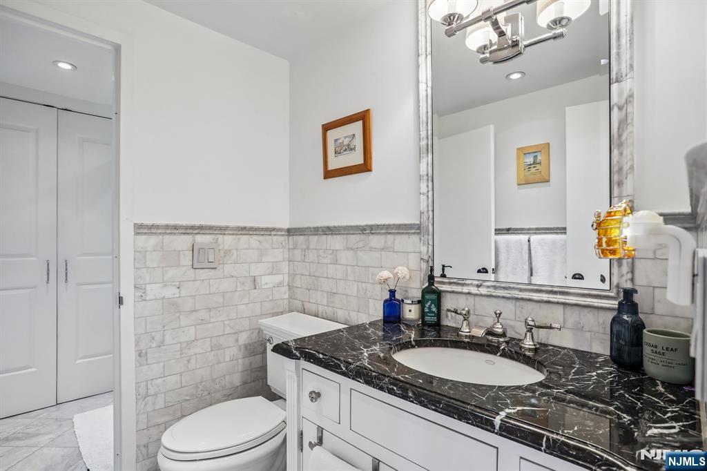 1077 River Road, Unit 303 Edgewater, NJ 07020 - Photo 22 of 27 a bathroom with a granite countertop toilet sink and mirror