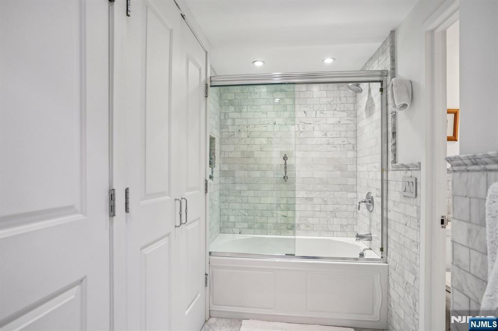 1077 River Road, Unit 303 Edgewater, NJ 07020 - Photo 24 of 27 a bathroom with a bathtub and a shower