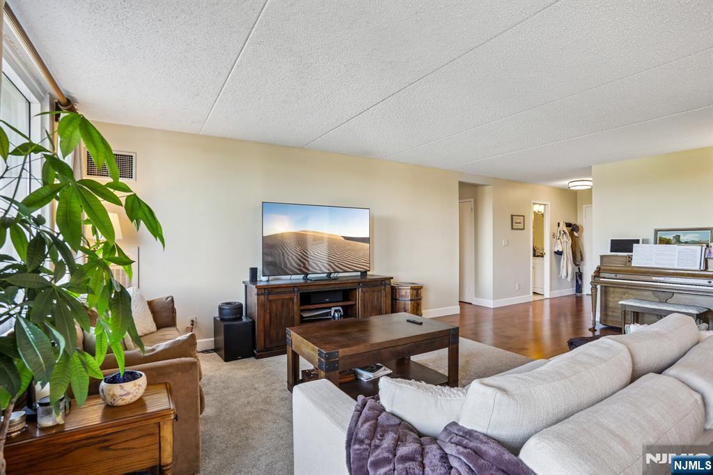 1077 River Road, Unit 303 Edgewater, NJ 07020 - Photo 6 of 27 a living room with furniture a potted plant and a kitchen view