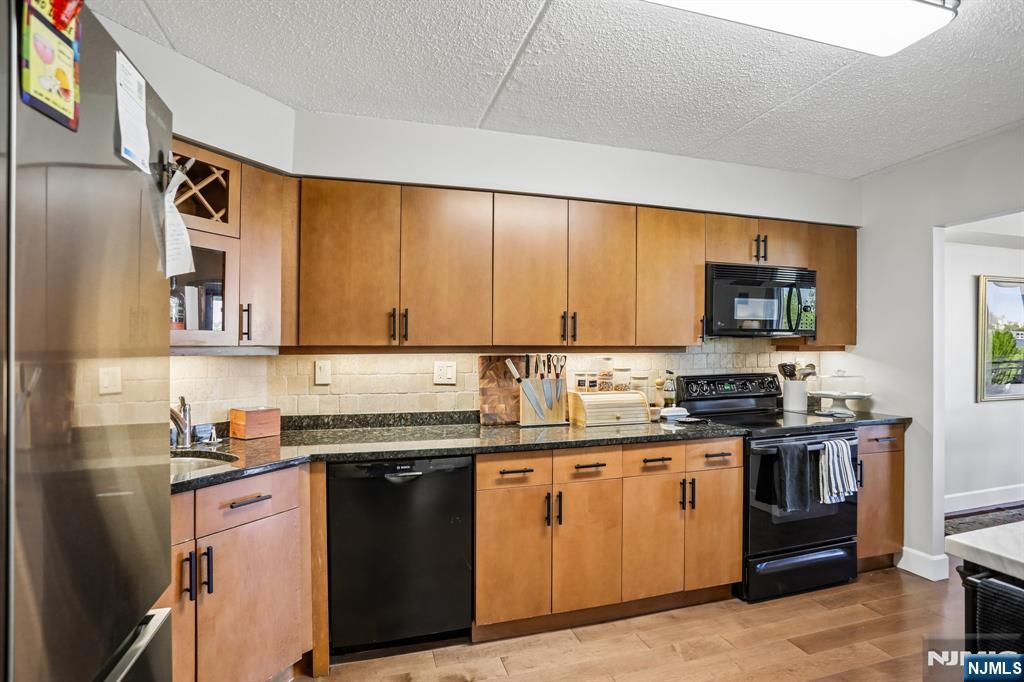 1077 River Road, Unit 303 Edgewater, NJ 07020 - Photo 9 of 27 a kitchen with stainless steel appliances granite countertop a sink stove and refrigerator