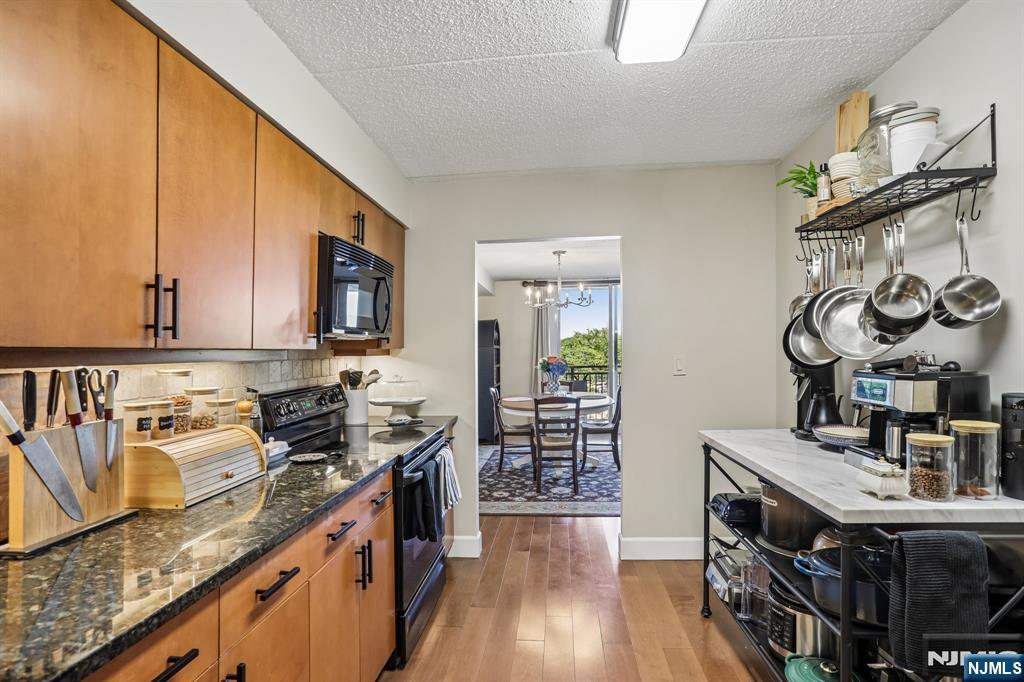 1077 River Road, Unit 303 Edgewater, NJ 07020 - Photo 10 of 27 a kitchen with stainless steel appliances granite countertop a stove and a sink