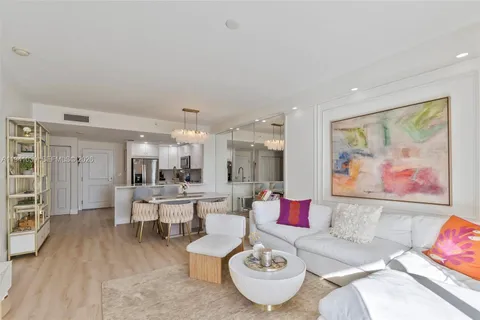 a living room with furniture and kitchen view