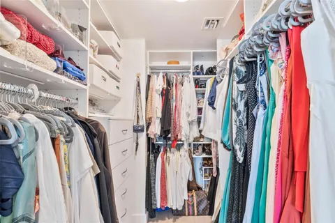 a view of walk in closet with clothes