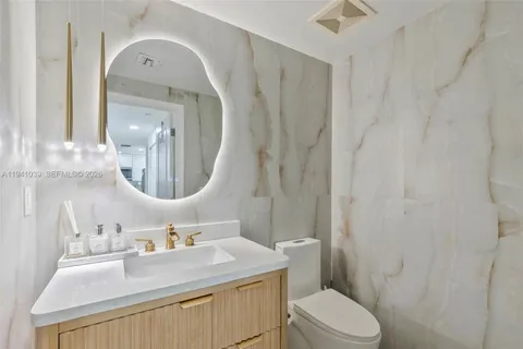 a bathroom with a sink vanity mirror and toilet