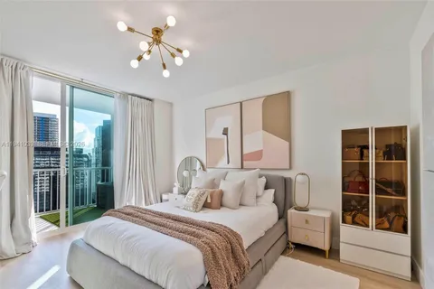 a bedroom with a large bed and a chandelier fan