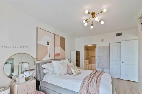 a bedroom with a large bed and a chandelier