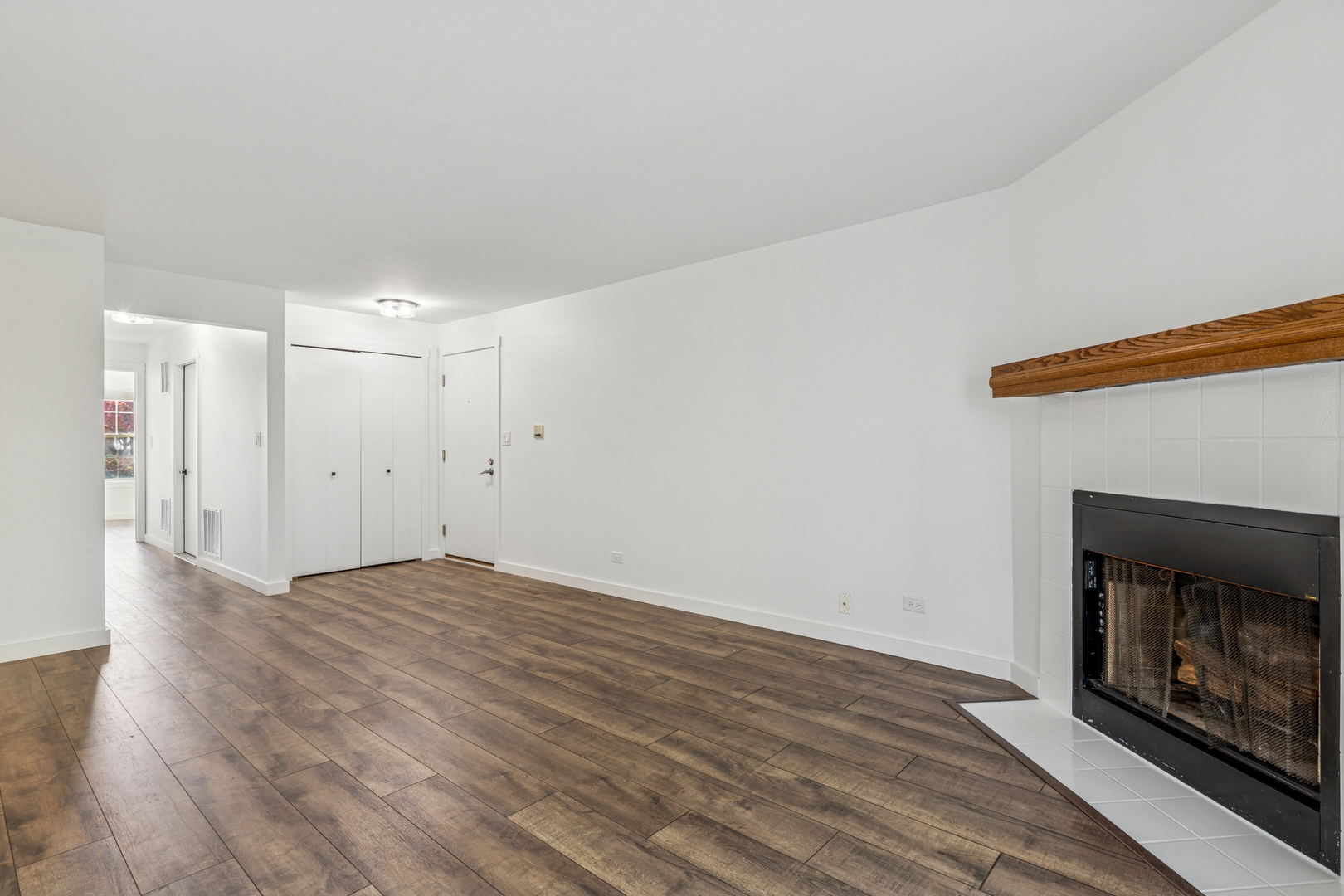 1240 Winfield Court, Unit 3 Roselle, IL 60172 - Photo 16 of 21 a view of an empty room with wooden floor fireplace and a window