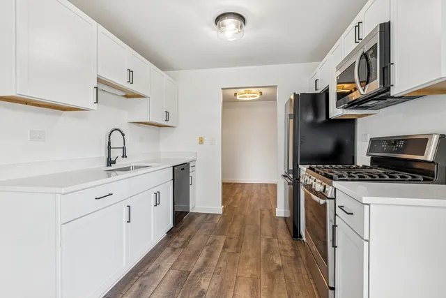 a kitchen with stainless steel appliances granite countertop a sink stove and refrigerator