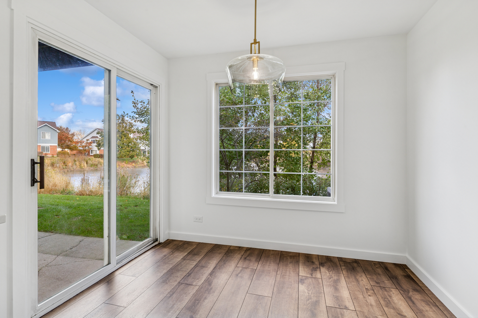 1240 Winfield Court, Unit 3 Roselle, IL 60172 - Photo 8 of 21 a view of an empty room with wooden floor and a window