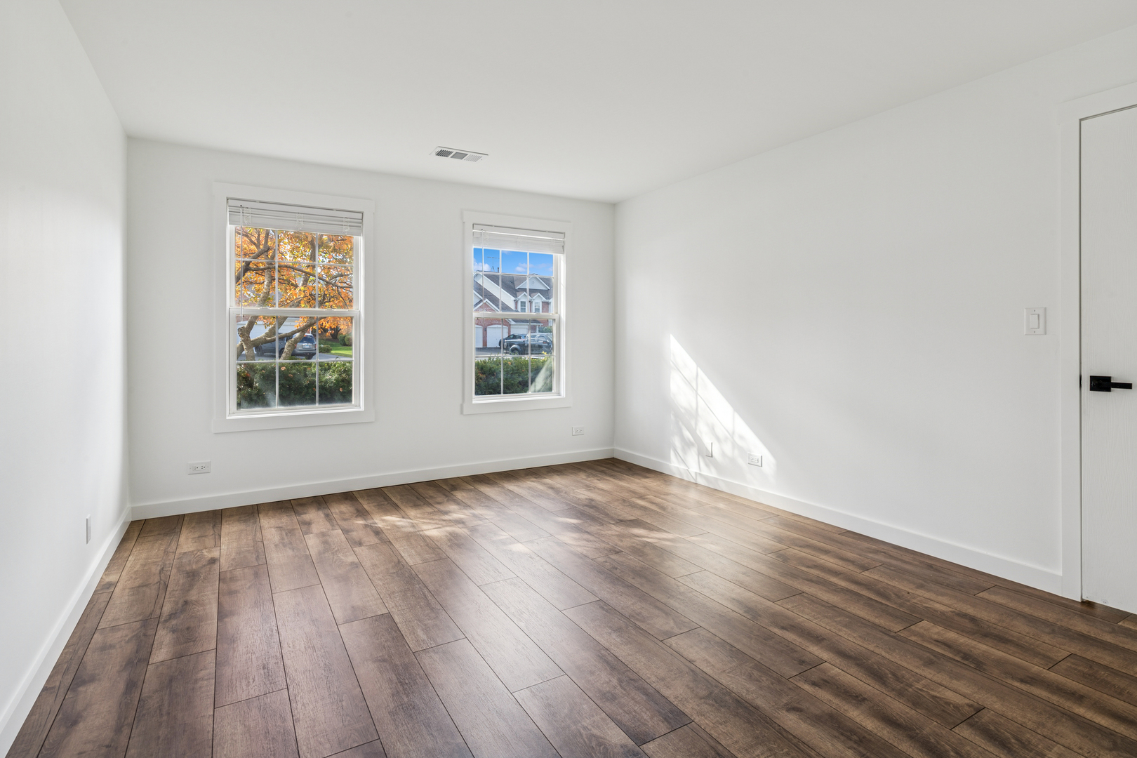 1240 Winfield Court, Unit 3 Roselle, IL 60172 - Photo 10 of 21 a view of an empty room with wooden floor and a window