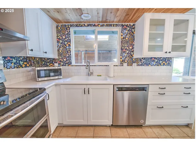 a kitchen with stainless steel appliances granite countertop a sink stove and cabinets