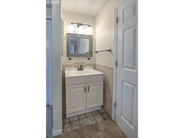 a view of an empty room with chandelier fan and fire place