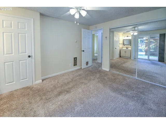 a view of a hallway with a chandelier fan and windows
