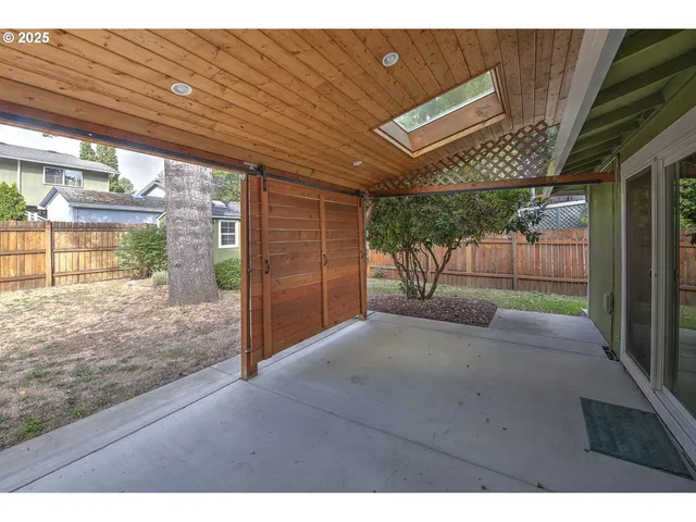 a view of a backyard with a garden and tree
