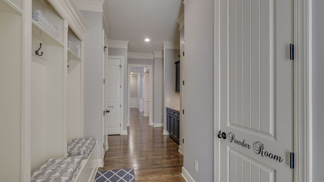 a view of a hallway with windows and chandelier