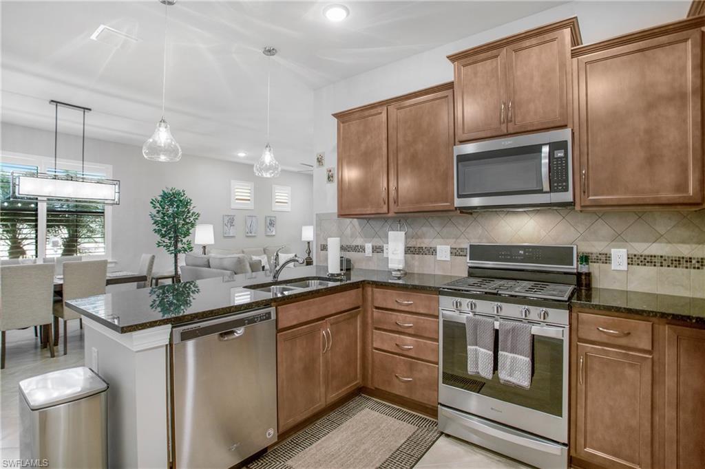 7674 Jacaranda Lane Naples, FL 34114 - Photo 13 of 45 a kitchen with a sink stove and microwave