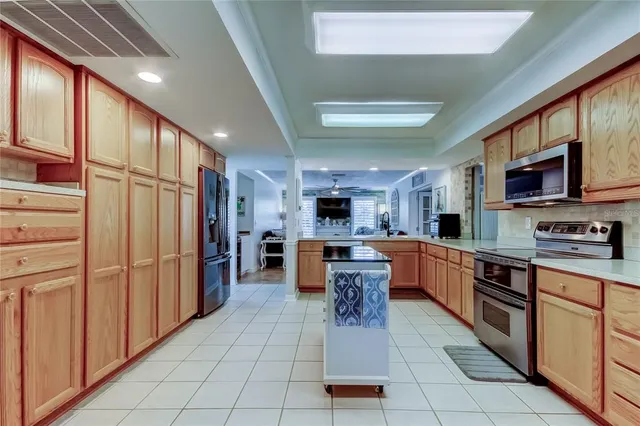 a kitchen with stainless steel appliances granite countertop a refrigerator a stove top oven and a sink with cabinets