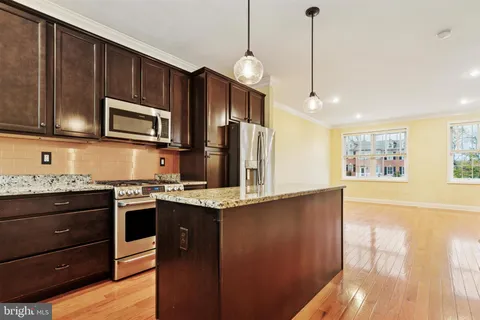 a kitchen with stainless steel appliances granite countertop a stove a sink and a microwave