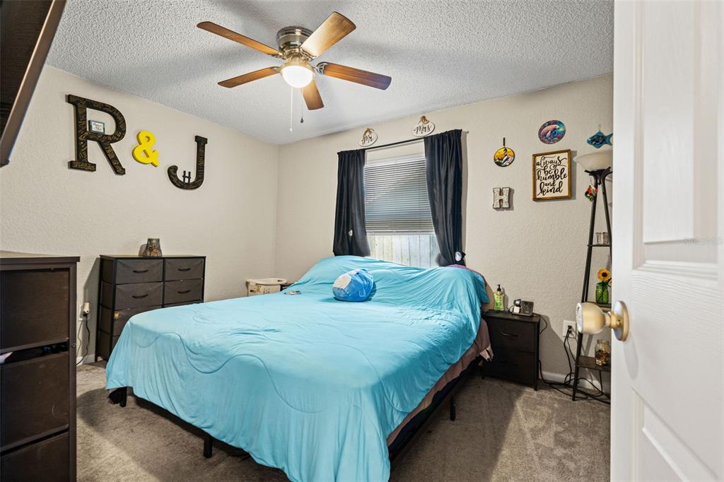 12292 Ronald Street Spring Hill, FL 34609 - Photo 8 of 18 a bedroom with a bed and a chandelier