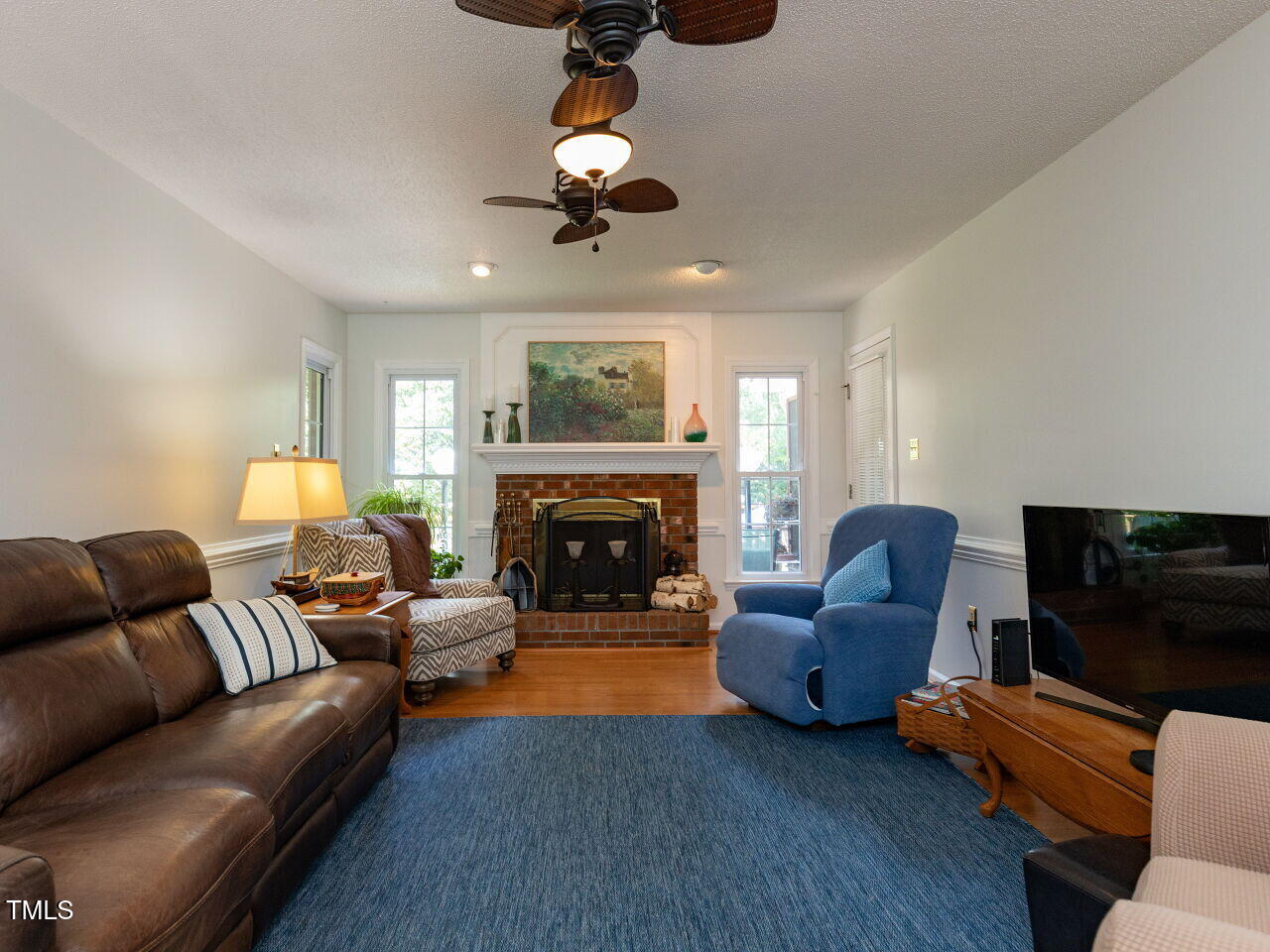 1025 Lake Path Road Willow Spring, NC 27592 - Photo 11 of 30 a living room with furniture a flat screen tv and a fireplace