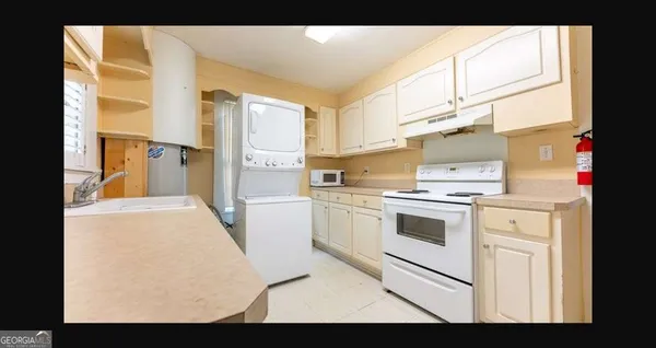 a kitchen with stainless steel appliances kitchen island granite countertop a stove a sink and a refrigerator