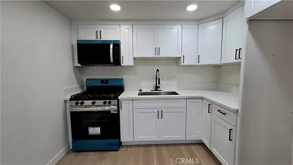 a kitchen with white cabinets and stainless steel appliances