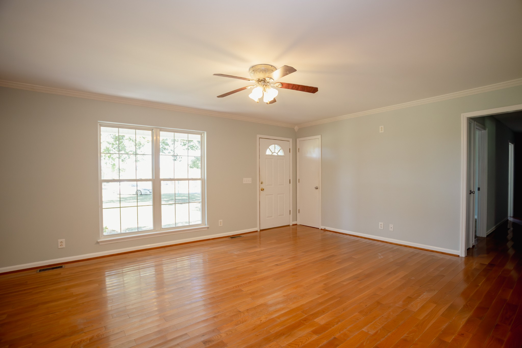 1052 Randy Road Ashland City, TN 37015 - Photo 7 of 30 an empty room with wooden floor chandelier fan and windows