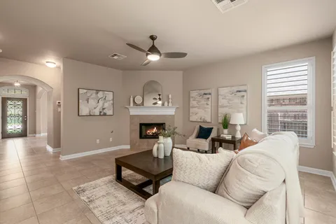 a living room with furniture a fireplace and a large window