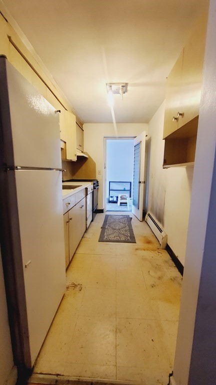 7 Commonwealth Court, Unit 5 Boston, MA 02135 - Photo 14 of 19 a large white kitchen with a refrigerator a stove top oven a sink and dishwasher