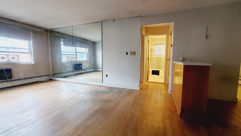 7 Commonwealth Court, Unit 5 Boston, MA 02135 - Photo 3 of 19 an empty room with wooden floor and windows