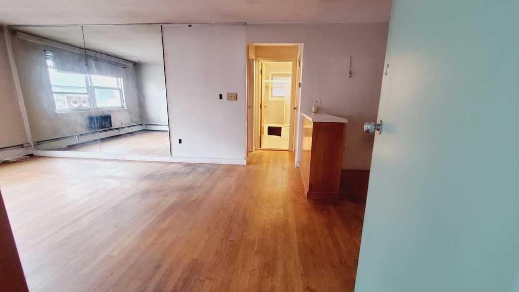 7 Commonwealth Court, Unit 5 Boston, MA 02135 - Photo 5 of 19 an empty room with wooden floor and windows
