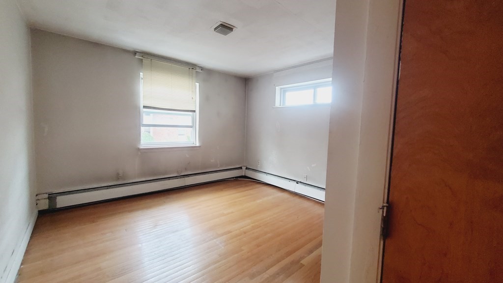 7 Commonwealth Court, Unit 5 Boston, MA 02135 - Photo 7 of 19 an empty room with wooden floor and windows
