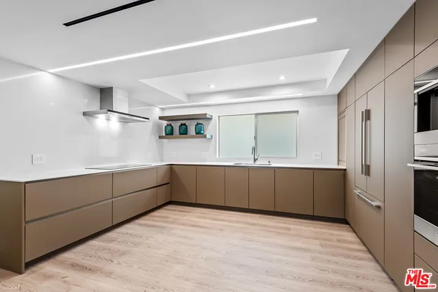 a kitchen with stainless steel appliances granite countertop a refrigerator and a stove top oven