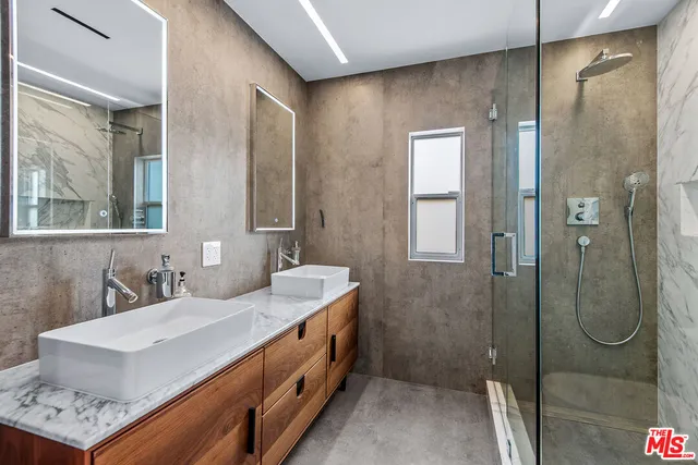 a bathroom with a double vanity sink mirror and shower
