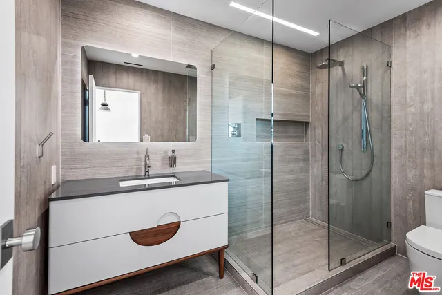 a bathroom with a shower sink vanity and mirror