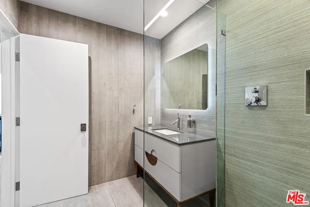 a bathroom with a sink a mirror and a shower