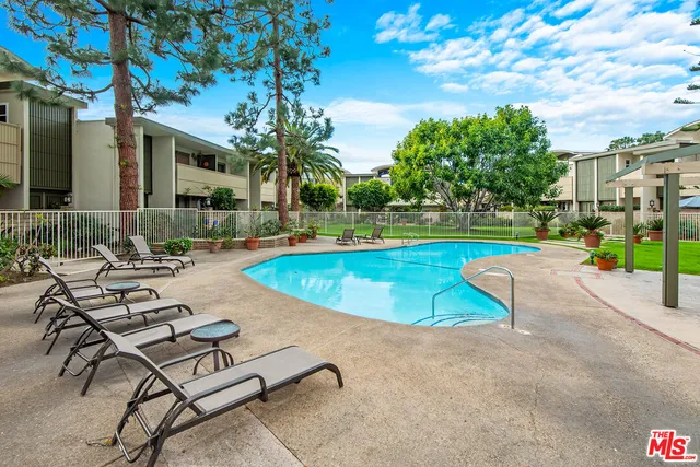 a view of a swimming pool with lounge chairs in patio