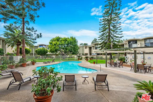 a view of a swimming pool with a lounge chair and potted plants