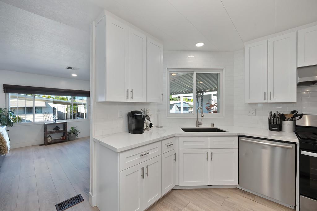 7512 Bufflehead Lane Citrus Heights, CA 95621 - Photo 22 of 52 a kitchen with a sink white cabinets and white appliances