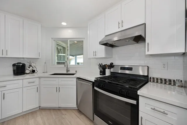 a kitchen with a sink a counter top stainless steel appliances and cabinets
