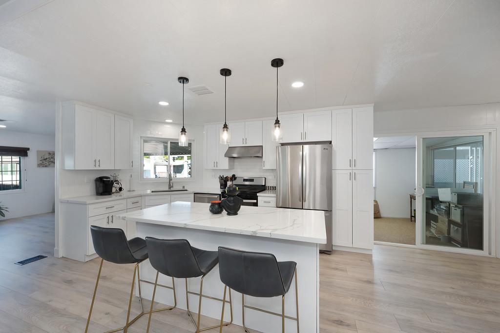 7512 Bufflehead Lane Citrus Heights, CA 95621 - Photo 27 of 52 a kitchen with stainless steel appliances kitchen island granite countertop a sink refrigerator and cabinets