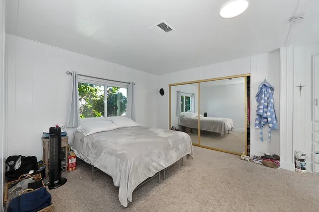 a bedroom with a bed and a white wall