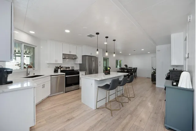 a kitchen with a sink a counter top space stainless steel appliances and cabinets