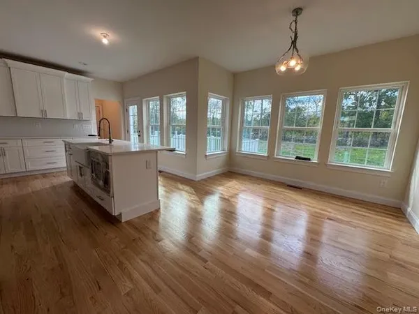 a large kitchen with large windows and wooden floor
