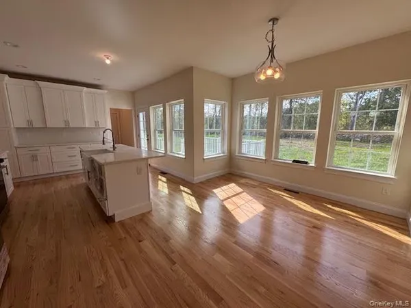 a kitchen with stainless steel appliances kitchen island granite countertop a stove a refrigerator and a wooden floors