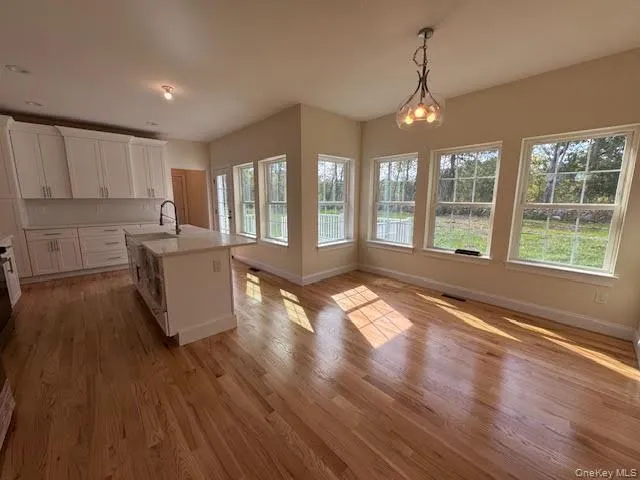 a kitchen with stainless steel appliances kitchen island granite countertop a stove a refrigerator and a wooden floors