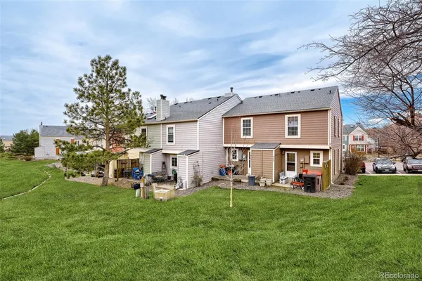 a front view of house with a garden and trees