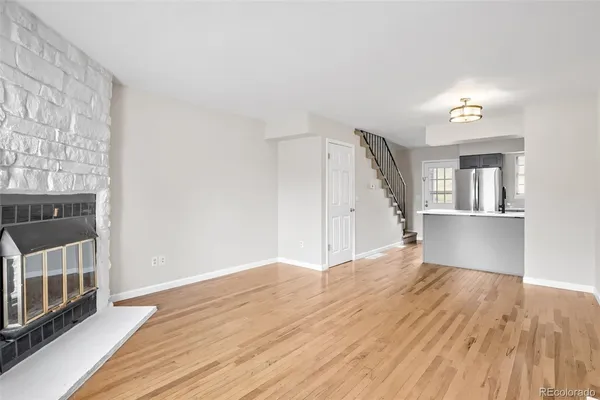 a view of a big room with wooden floor and windows