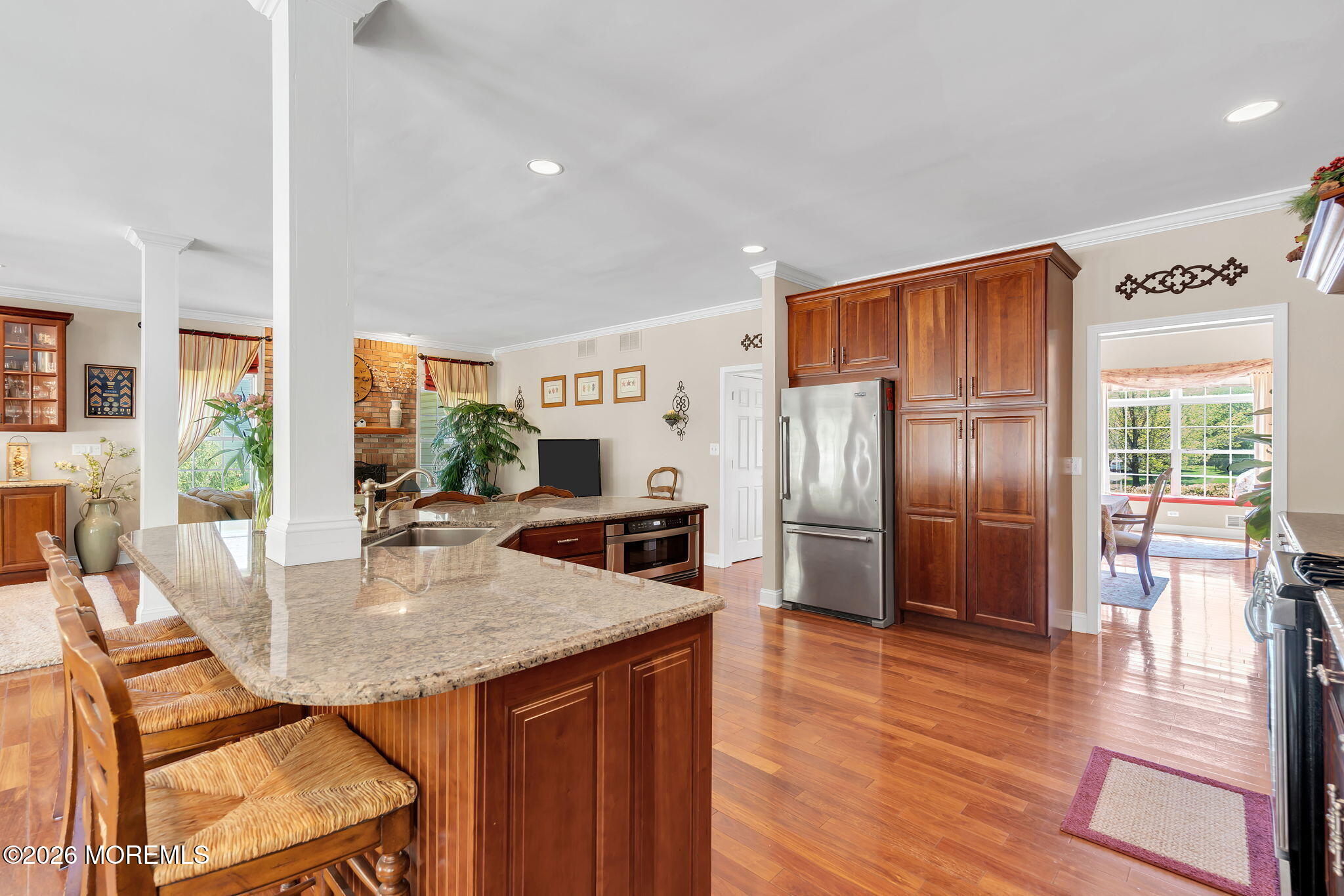 343 Nighthawk Lane Jackson, NJ 08527 - Photo 24 of 72 a kitchen with stainless steel appliances granite countertop a refrigerator a stove a sink a dining table and chairs with wooden floor