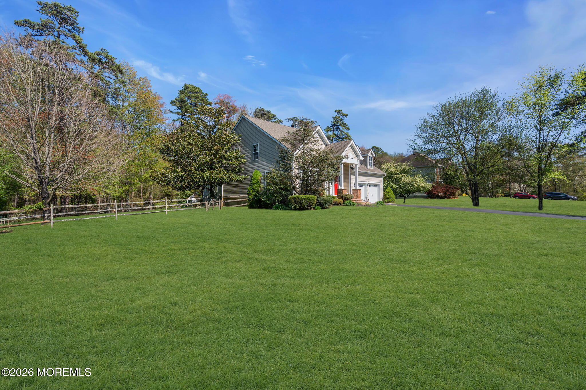 343 Nighthawk Lane Jackson, NJ 08527 - Photo 9 of 72 a view of a white house in front of a big yard with plants and large trees